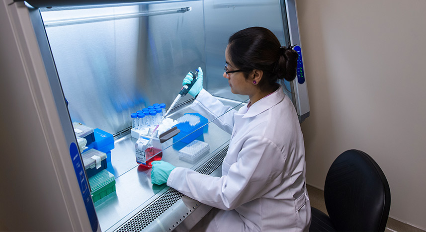 Student in labcoat working in a science lab