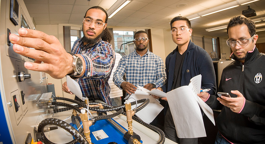 Students examining a machine